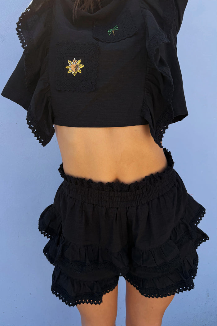 Black Ruffle Shorts with tiered lace trim and an elasticated waistband, styled as a co-ord with a matching embroidered top.