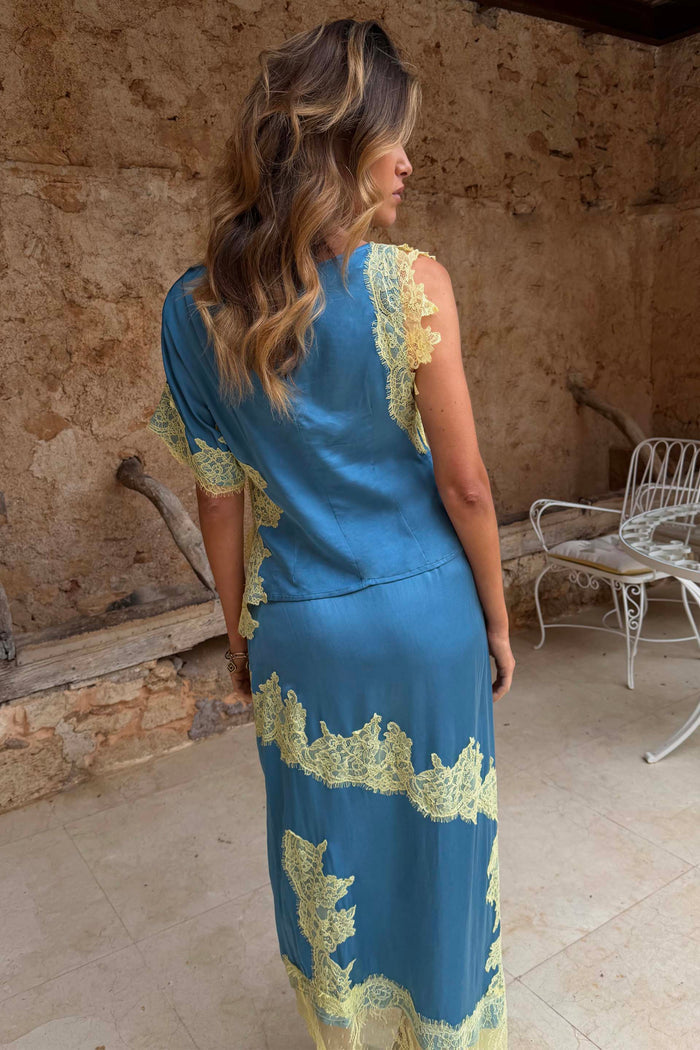 Blue and Lemon Kira Top featuring contrast lace and an asymmetric hem, worn as a co-ord and shown from the back.
