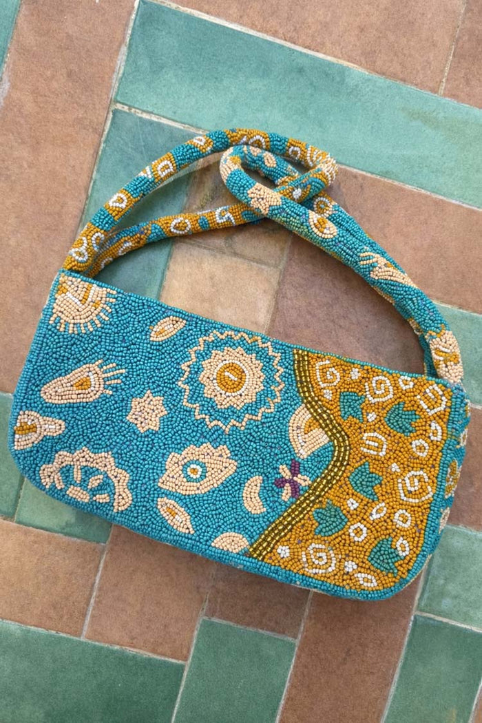 Blue and Yellow Morocco Beaded bag featuring hand-embellished glass beads and iconic motifs on a tiled background.