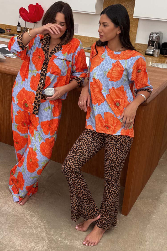 Blue Poppy Print Jersey Pyjamas with vibrant orange flowers and leopard print accents shown on two models.