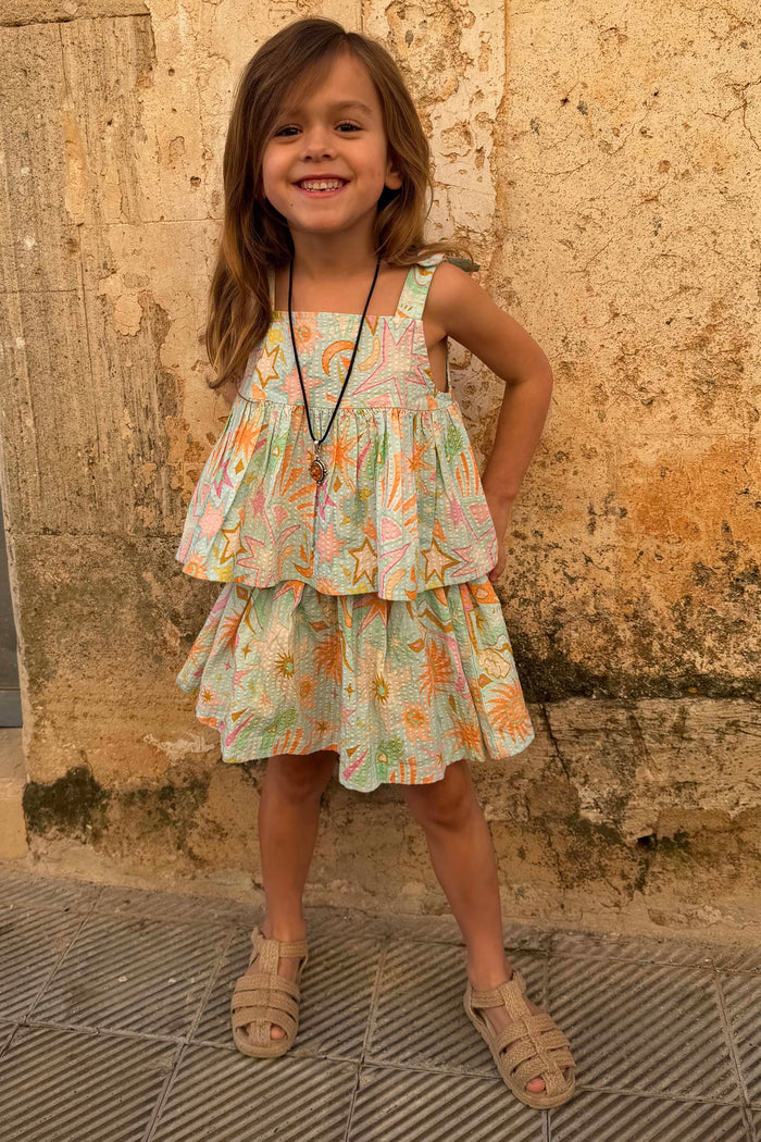 Blue Starburst cotton co-ord set with sun and star motifs, featuring a peplum top and tiered skirt on a girl.