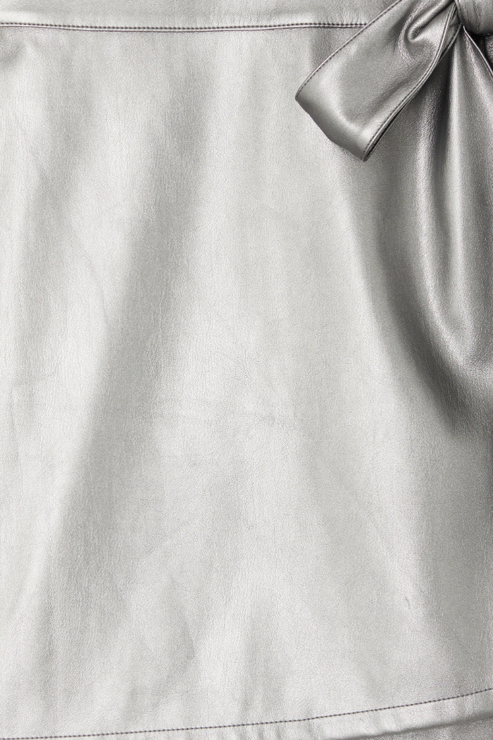 Gunmetal vegan leather detail of the Jaspre mini skirt showing metallic texture and wrap tie fastening.