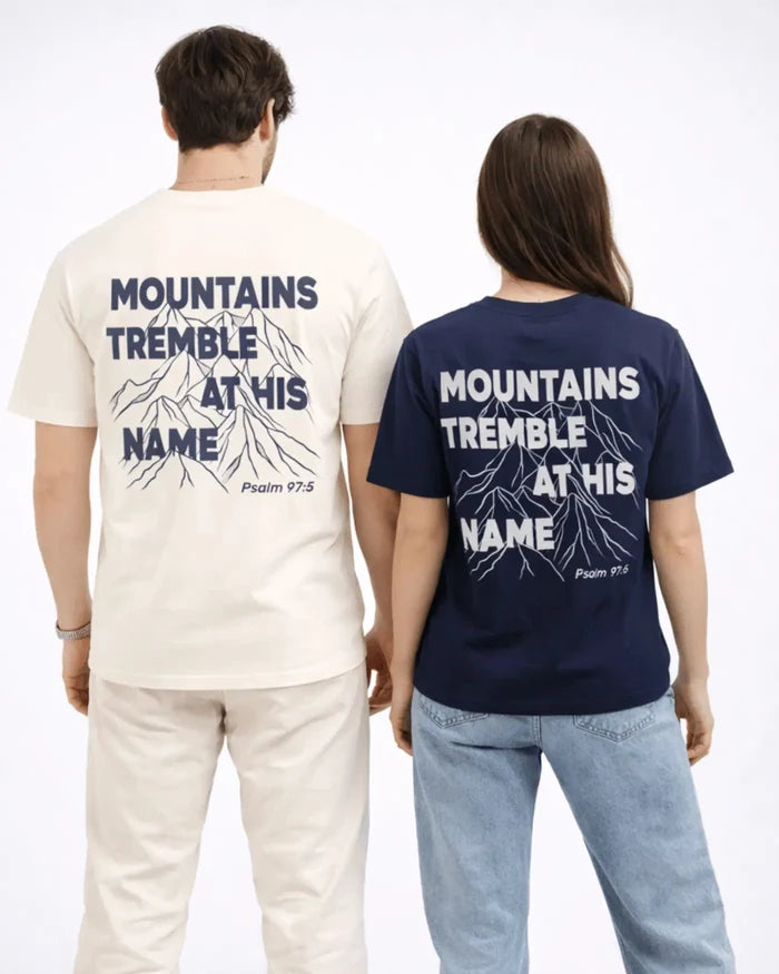 Two people wearing t-shirts with 'Mountains Tremble at His Name' text on the back.
