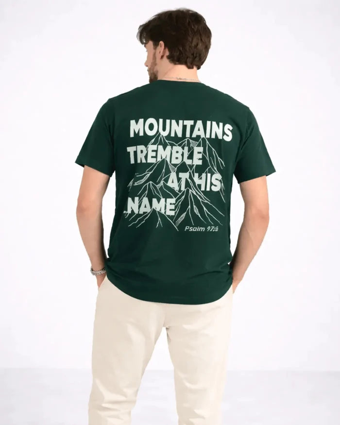 Person wearing a green t-shirt with text and mountain graphic on the back, on a white background