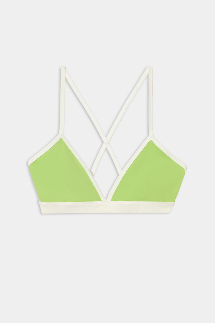 The SPLITS59 Sage Rigor Bra in Limeade/White features a light green design with white trim, thin crisscross back straps, and is crafted from a soft nylon-spandex blend. It is showcased on a plain white background.
