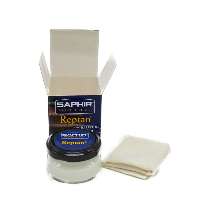 A box of Saphir REPTAN Reptile Beauty Milk with a 50ml measure indicated, alongside a chamois cleaning cloth.