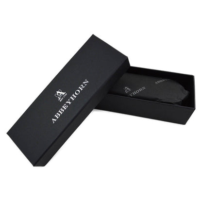 A handcrafted shoe polishing brush with a black and white oxhorn handle and dark bristles, presented on a plain background.