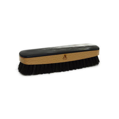A handcrafted shoe polishing brush with a black and white oxhorn handle and dark bristles, presented on a plain background.