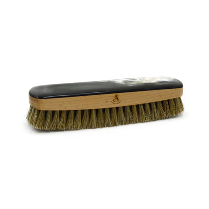 A handcrafted shoe polishing brush with a black and white oxhorn handle and dark bristles, presented on a plain background.