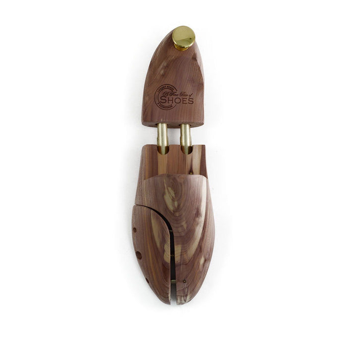 A pair of uncompressed cedar wood shoe trees with brass fitments, displayed in an open position.