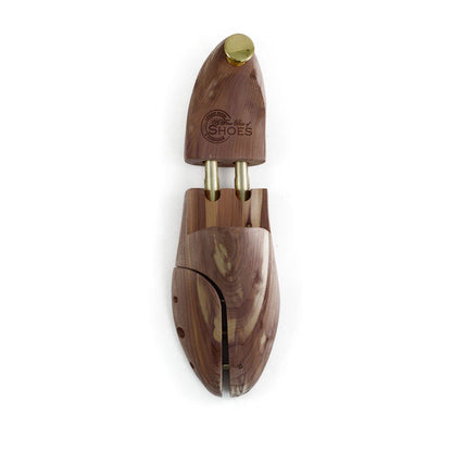 A pair of uncompressed cedar wood shoe trees with brass fitments, displayed in an open position.