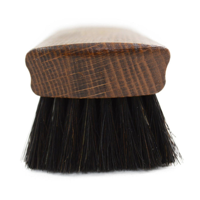 A wooden shoe shine brush with horsehair bristles, one with the brand 'AFPOS' visible on the top.