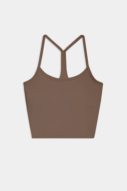 The SPLITS59 Airweight Crop - Lentil is a brown racerback tank with thin straps, ideal for hot yoga. Shown laid flat on a white background.