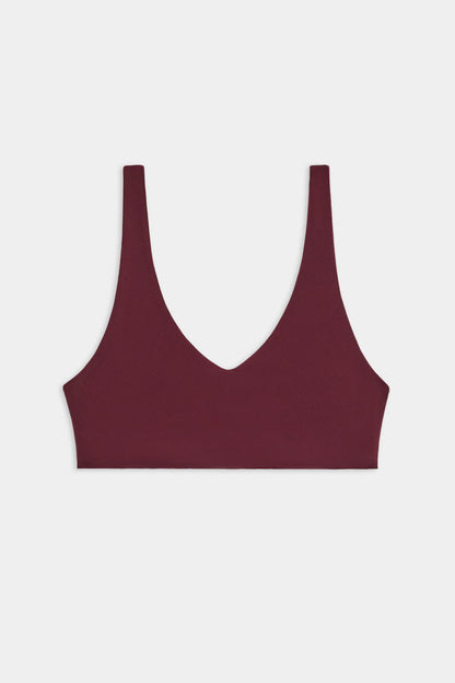 The SPLITS59 Airweight Scoop Back Bra, shown in burgundy with a deep V-neckline and wide shoulder straps, is displayed against a plain white background.