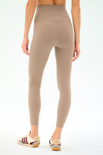 Wearing SPLITS59’s Airweight Super High Waist 7/8 leggings in Latte with taupe and beige sneakers featuring maroon stripes, this look is ideal for hot yoga thanks to the ultra luxe Airweight fabric.