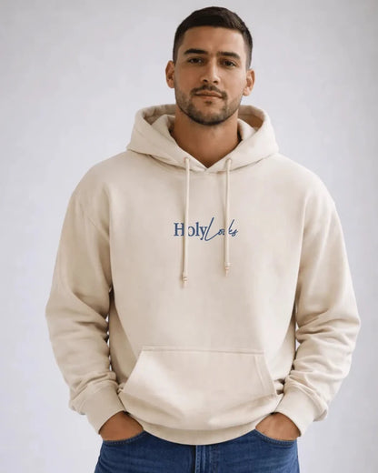 Man wearing a beige hoodie with 'Holy Lake' text on a plain background