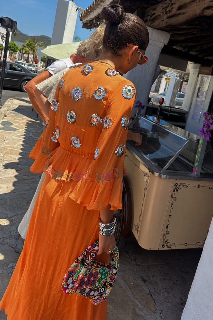Apricot Embellished Ines Dress in orange featuring mirror embroidery and a ruffled peplum hem on vacation.