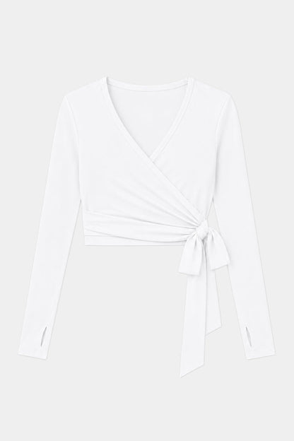 The SPLITS59 Bella Airweight Lite Wrap in white is a long-sleeve V-neck top made from a soft spandex-nylon blend with a side tie detail, shown on a plain light background.