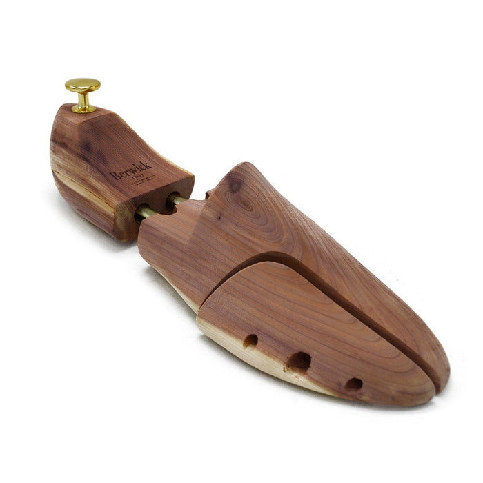 A Berwick 1707 cedar wood shoe tree with brass fitments, displayed in an open position showing the interior structure.