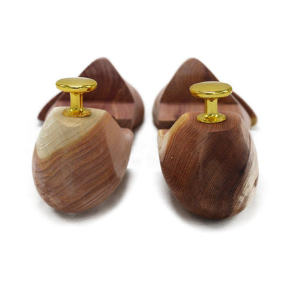 A Berwick 1707 cedar wood shoe tree with brass fitments, displayed in an open position showing the interior structure.