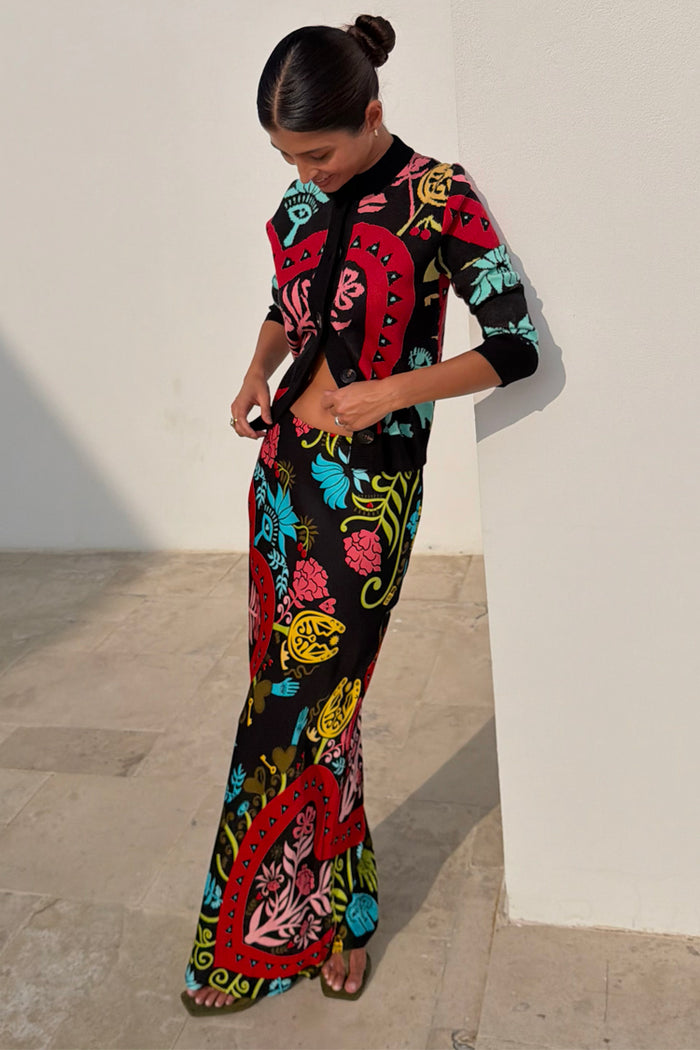 Black Amara Dorris Midi Skirt with hand painted heart and eye motifs, designed in London and styled with a cardigan.