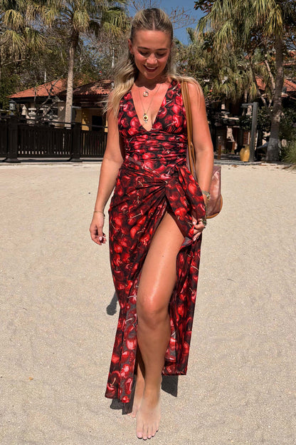 Black Cherry Sarong with a red cherry print and tie-waist, styled over a matching swimsuit for a beach vacation.