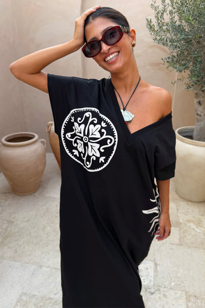 Black cotton Dolce Vita T-Shirt Dress featuring white sun motifs and a multi-wear, off-the-shoulder neckline.