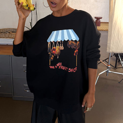 Black Fruit Shop Sweatshirt with an in-house designed fruit stall graphic, relaxed fit, worn by a model holding bananas.
