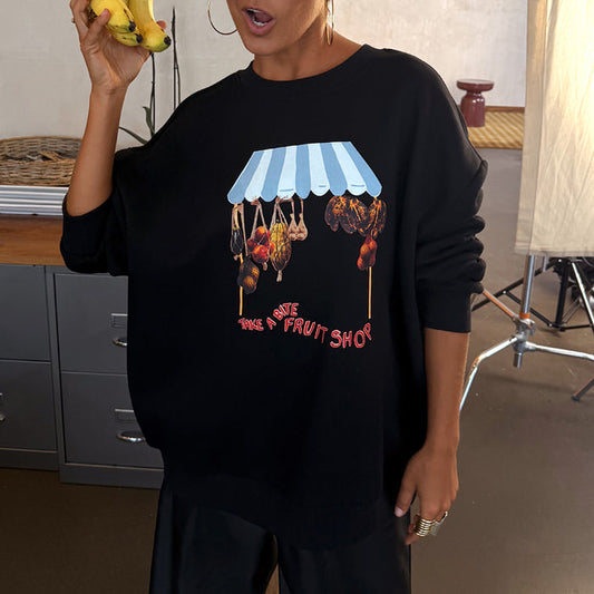 Black Fruit Shop Sweatshirt with an in-house designed fruit stall graphic, relaxed fit, worn by a model holding bananas.