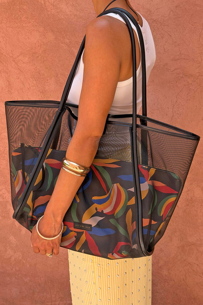 Black Mesh Tote Bag with leather straps and a colourful banana print pouch, styled over a model's shoulder.