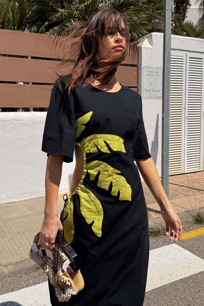 Black Palm Riviera Dress featuring green palm motifs and adjustable side cut-out detailing.
