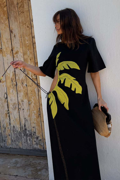 Black Palm Riviera Dress featuring a yellow palm leaf motif and side cut-out with tie detailing.