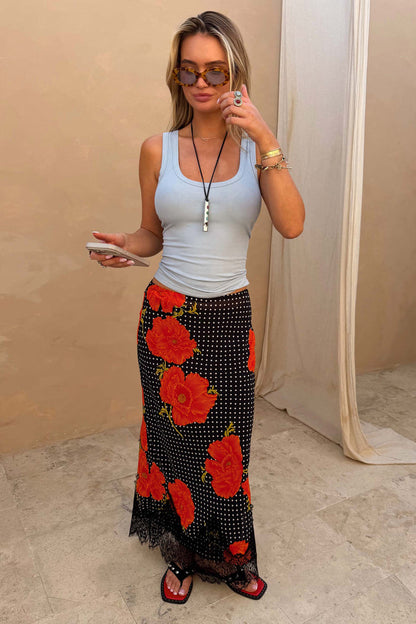 Black Poppy Midi Maeva Skirt with a red floral print and lace trim, paired with a light blue ribbed tank top.