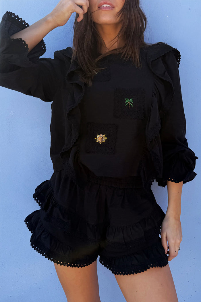 Black Ruffle Shorts with tiered lace trim, styled as a co-ord with a matching long-sleeve embroidered top.