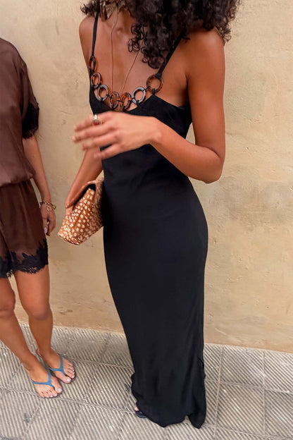 Black Sapna maxi dress featuring a sleek fitted silhouette and tortoise-shell ring detailing across the neckline.