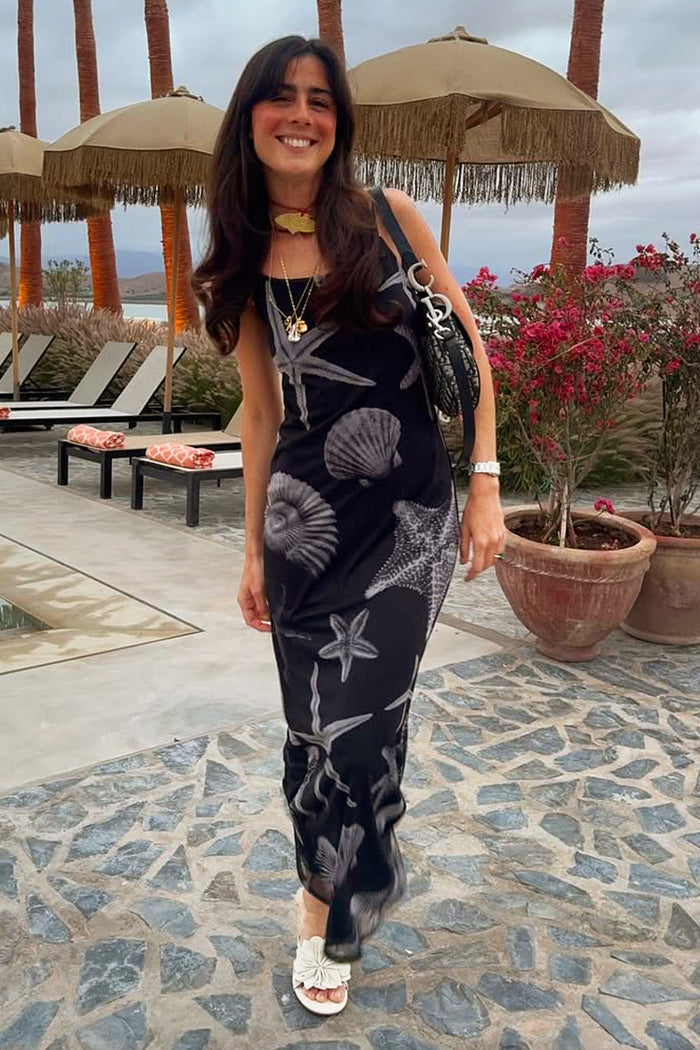 Black Seashell Mesh Cami Dress with white starfish and shell prints, styled for a summer vacation.