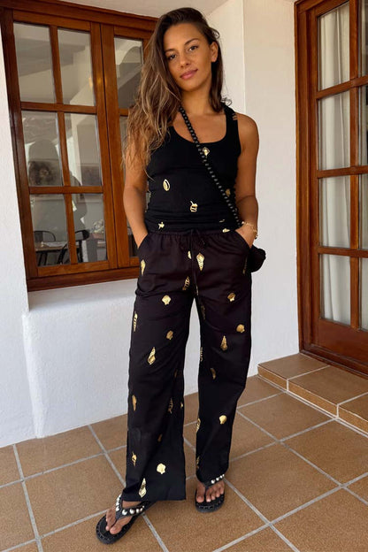 Black Shell Elissa Trousers Petite with a gold seashell print, wide-leg cut and drawstring waist.