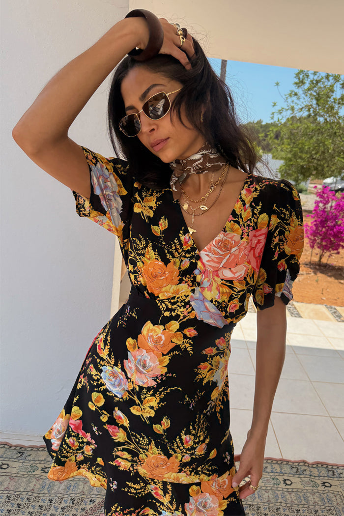 Black Sofia Mini Tea Dress with a vibrant yellow and pink rose print, V-neckline and frill hem.