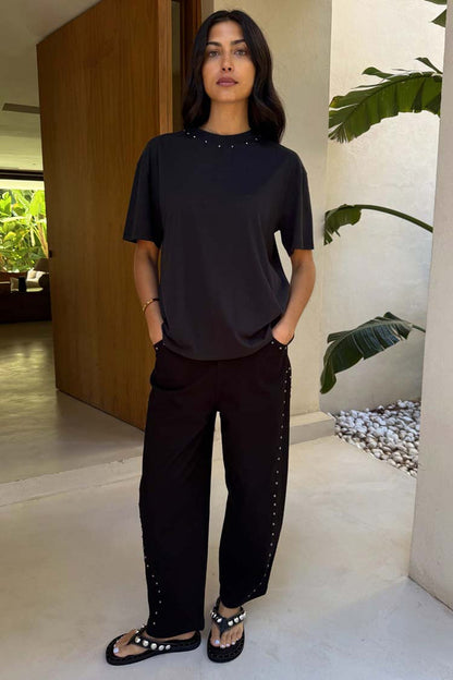 Black Studded Barrel Jeans featuring silver stud detailing along the sides, styled with a matching black t-shirt.