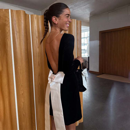 Black Velvet Bow Mini Dress with an open back and large cream detachable bow, designed in London.
