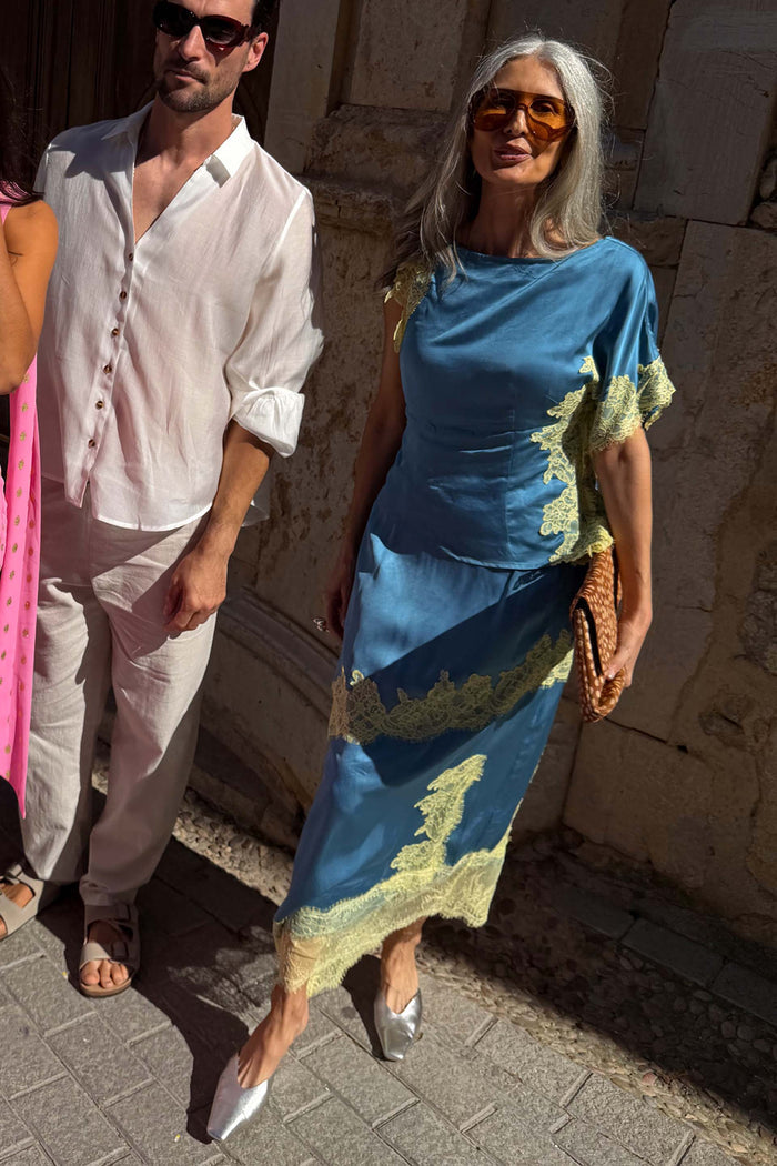 Blue satin Millie Skirt featuring a lemon lace asymmetric hem, styled as a co-ord for wedding guest looks.