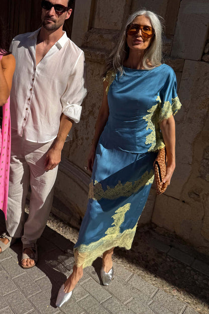 Blue satin Millie Skirt featuring a lemon lace asymmetric hem, styled as a co-ord for wedding guest looks.