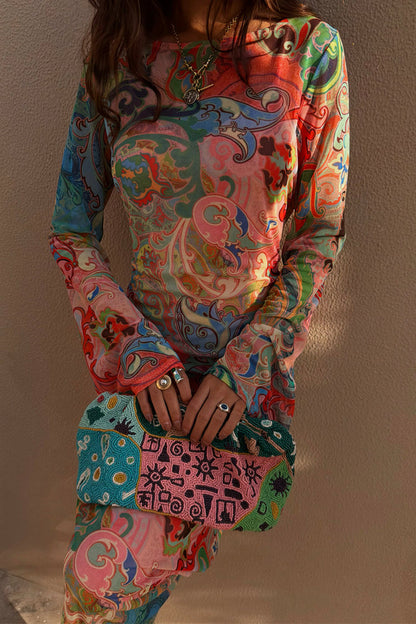 Blue Mari Aria Mesh Dress featuring a pink and blue paisley print with long sleeves and beaded clutch.