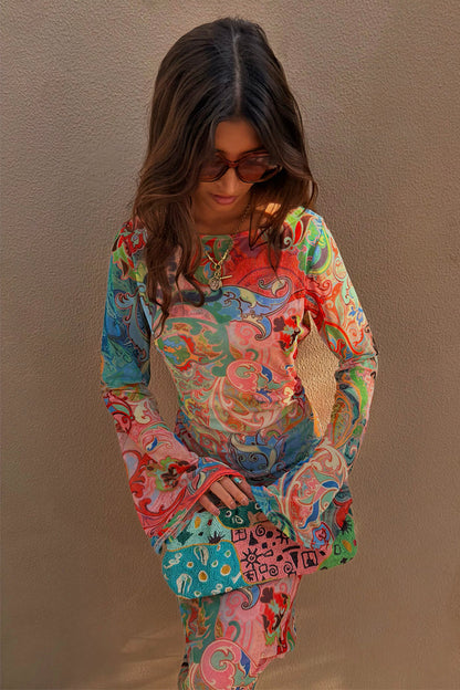 Blue Mari Aria Mesh Dress with a multi-colour paisley print, flared sleeves and a beaded clutch bag.