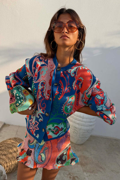 Blue Mari Cardigan with orange and turquoise paisley motifs, gold studs and a button-up front, designed in London.