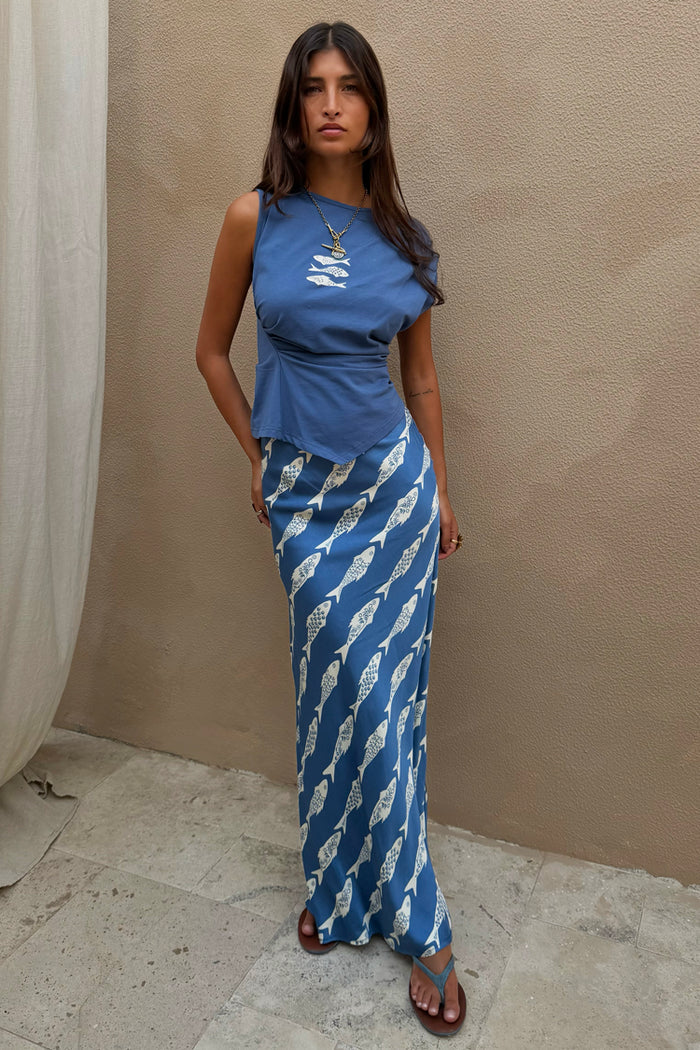 Blue Marina A-Symmetric Top with white fish motifs and gathered waist detailing, styled with a matching skirt.