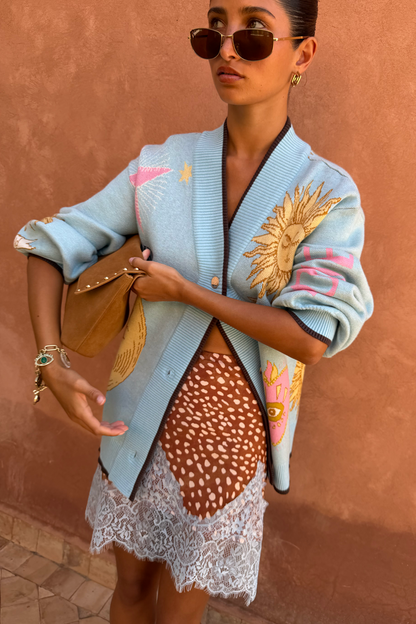 Blue Mystical Cardigan with golden sun jacquard motifs and contrast brown trims, styled with a leopard print lace skirt.