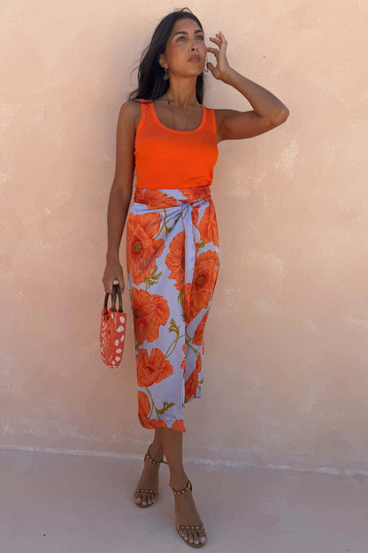 Iconic Blue Poppy Jaspre Skirt with an orange poppy print and wrap tie fastening on a model.
