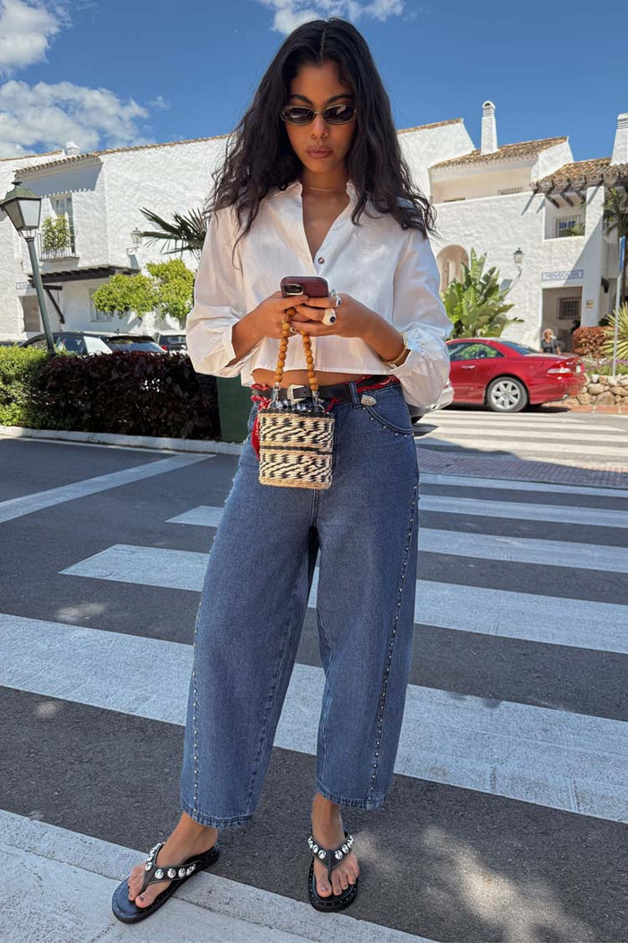 Blue Studded Barrel Jeans with side studs and a structured barrel leg, styled with a white shirt.