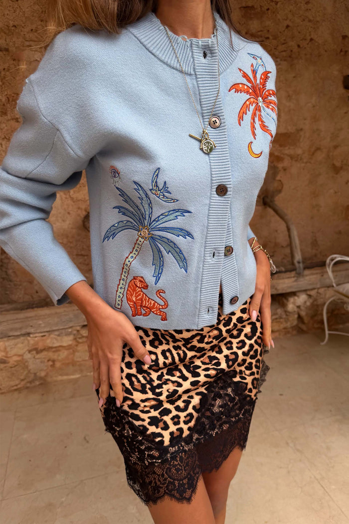 Blue Tigress Cardigan in pale blue knit with palm and tiger motifs, styled with a leopard print lace trim skirt.